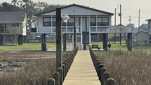 A wooden boardwalk leading to a building with a balcony.