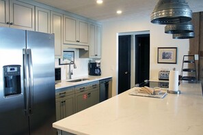 Enjoy cooking in this well-equipped kitchen with a refrigerator, water dispenser, coffee maker, and toaster.