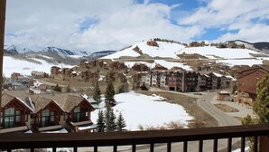 Une station de montagne avec des pistes enneigées, des chalets en bois et une route sinueuse.