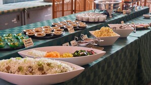 Un buffet proposant une variété de plats, notamment du riz, des légumes et de la viande.