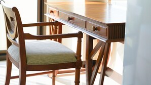 Una habitación con un escritorio de madera, una silla y un refrigerador blanco.