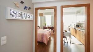 A bedroom with a bed, bedside table, and a wall-mounted light fixture spelling "SEVEN". - SEVEN GUEST HOUSE, a departing point to visit Lisbon and Sintra (Casal de São Brás)