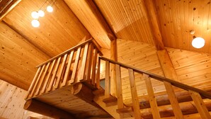 A wooden staircase with a railing leading to an upper level. - Urube Village (Tsumagoi)