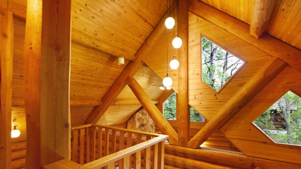 A wooden cabin with a wooden staircase, a wooden ceiling, and a window with a view of trees. - Urube Village (Tsumagoi)