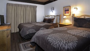 A hotel room with two beds, a wooden desk, a television, and a nightstand with a lamp. - Great Location! Ski-In/Out Condo. Mountain Views, Fireplace. (Mt. Crested Butte)