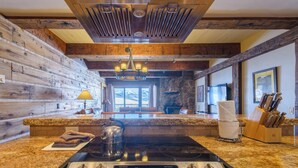 Uma cozinha com bancadas de granito, fogão de aço inoxidável e painel de backsplash de pedra.