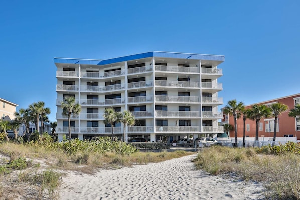 Ein mehrstöckiges Hotel mit Balkonen in Strandnähe.