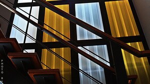 A staircase with wooden railings and a ceiling light fixture. - Merdelong Hotel (Phatthalung)