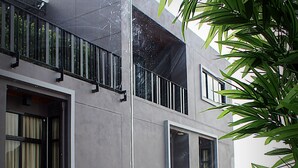 A multi-story building with large windows and a balcony. - Merdelong Hotel (Phatthalung)