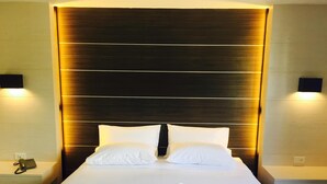 A hotel room with a large bed, two bedside lamps, and a telephone on the nightstand. - Merdelong Hotel (Phatthalung)