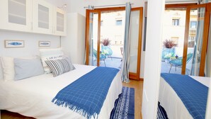 Ein Schlafzimmer mit Bett, Fenster und Blick ins Freie.