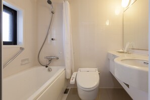 A bathroom with a bathtub, toilet, and sink.