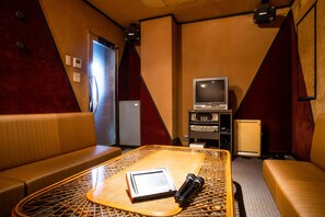 A room with a bed, a table with a tablet and a microphone, a television, and a refrigerator. - Ryokufukaku (Toyooka)