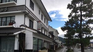 Et traditionelt japansk hotel med en skiltning, store vinduer og en fortov med taktil belægning.