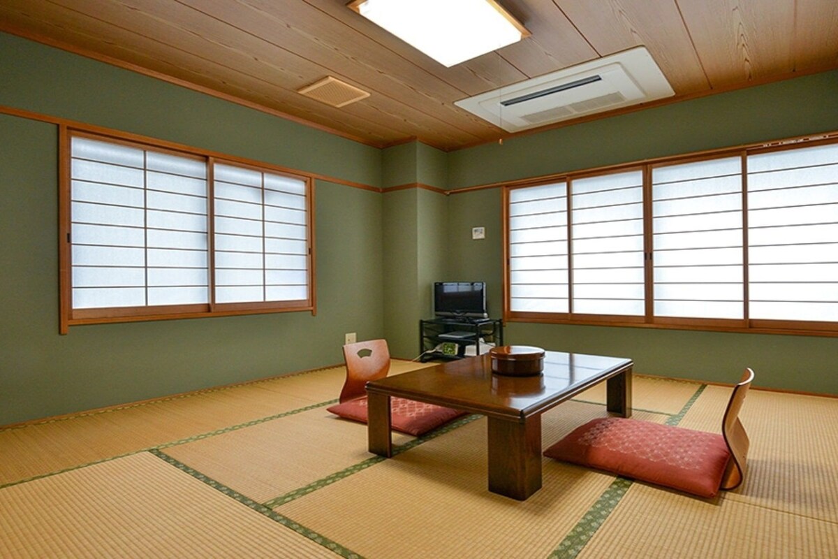 A traditional Japanese room with tatami flooring, a low table, and sliding shoji doors.