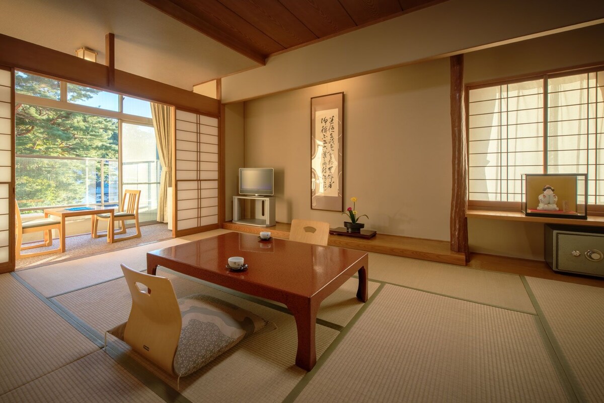 Une pièce de style japonais traditionnel, avec un sol recouvert de tatamis, une basse table en bois et des portes coulissantes en papier de riz (shoji).