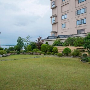 A multi-story building with a flat roof and a well-maintained garden in front. - Katayamazu Hot Spring Motoyu Hotel Kanoya Korakuen (Kaga)