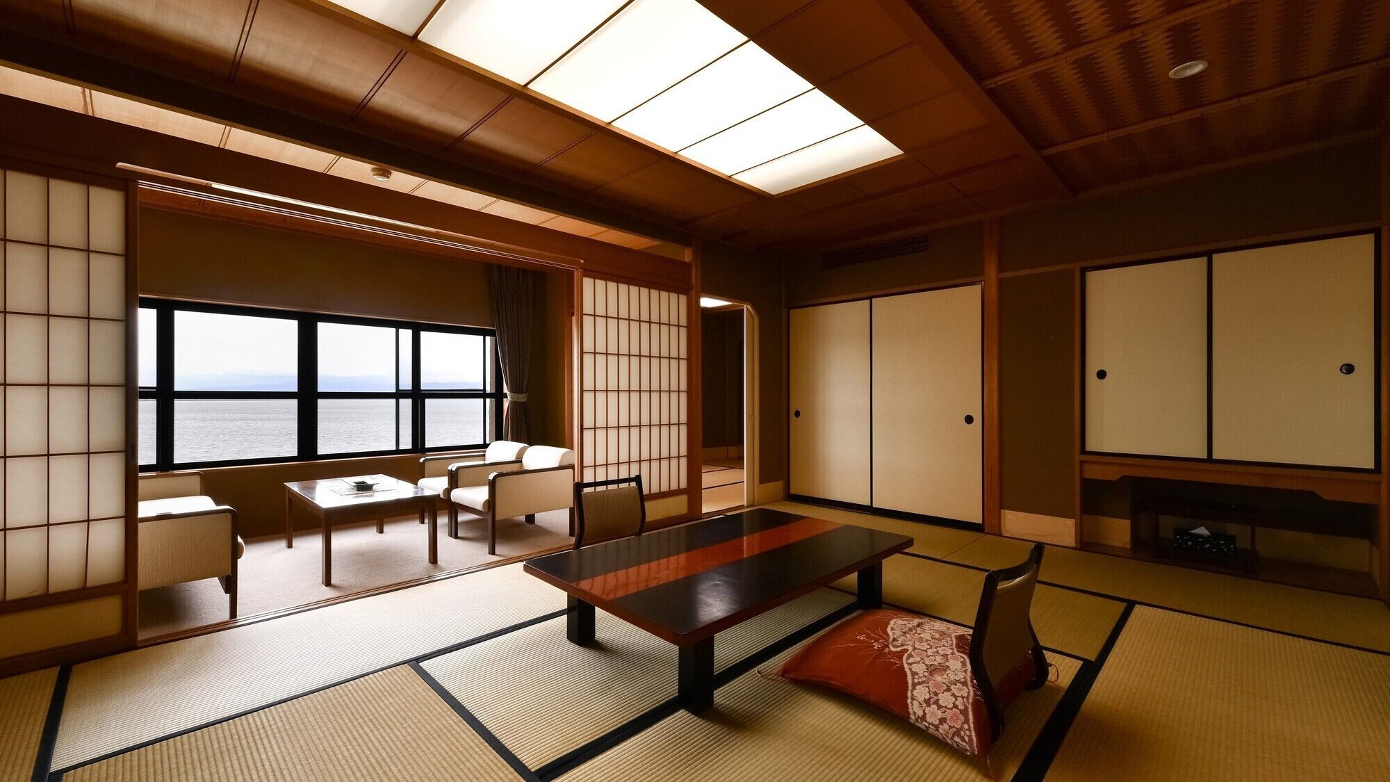A traditional Japanese room with tatami flooring, a low table, and sliding doors.