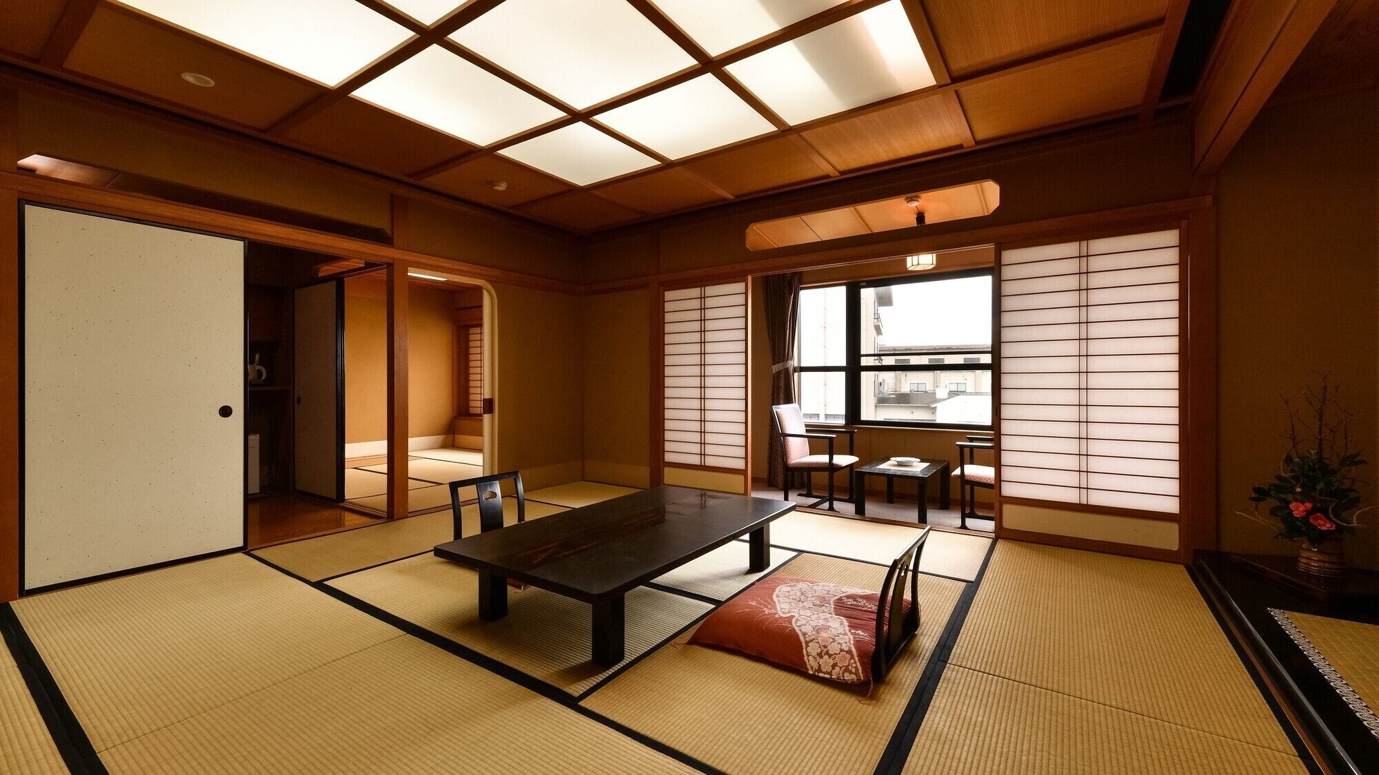 A traditional Japanese room with tatami flooring, a low table, and sliding doors.
