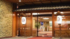 A traditional Japanese entrance with wooden gates and lanterns, leading to an interior with a reception desk and seating area. - Katayamazu Hot Spring Motoyu Hotel Kanoya Korakuen (Kaga)