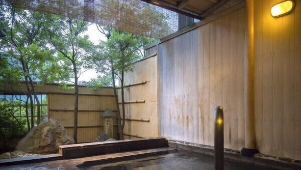 A traditional Japanese onsen with a wooden exterior, a stone hot spring, and a small stone lantern. - Katayamazu Hot Spring Motoyu Hotel Kanoya Korakuen (Kaga)