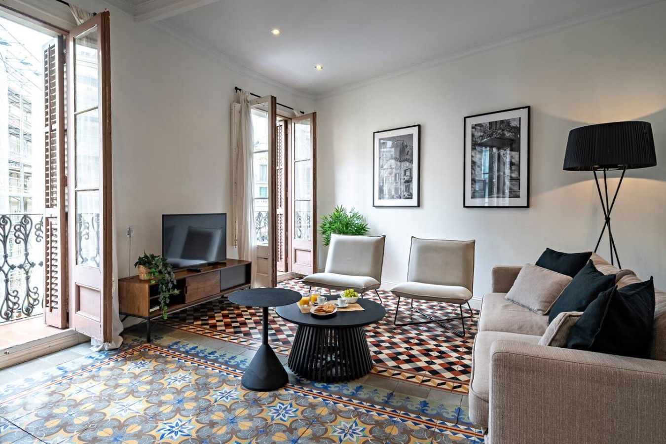 Een moderne woonkamer met een televisie, zitplaatsen, een salontafel en kunstwerken aan de muren.