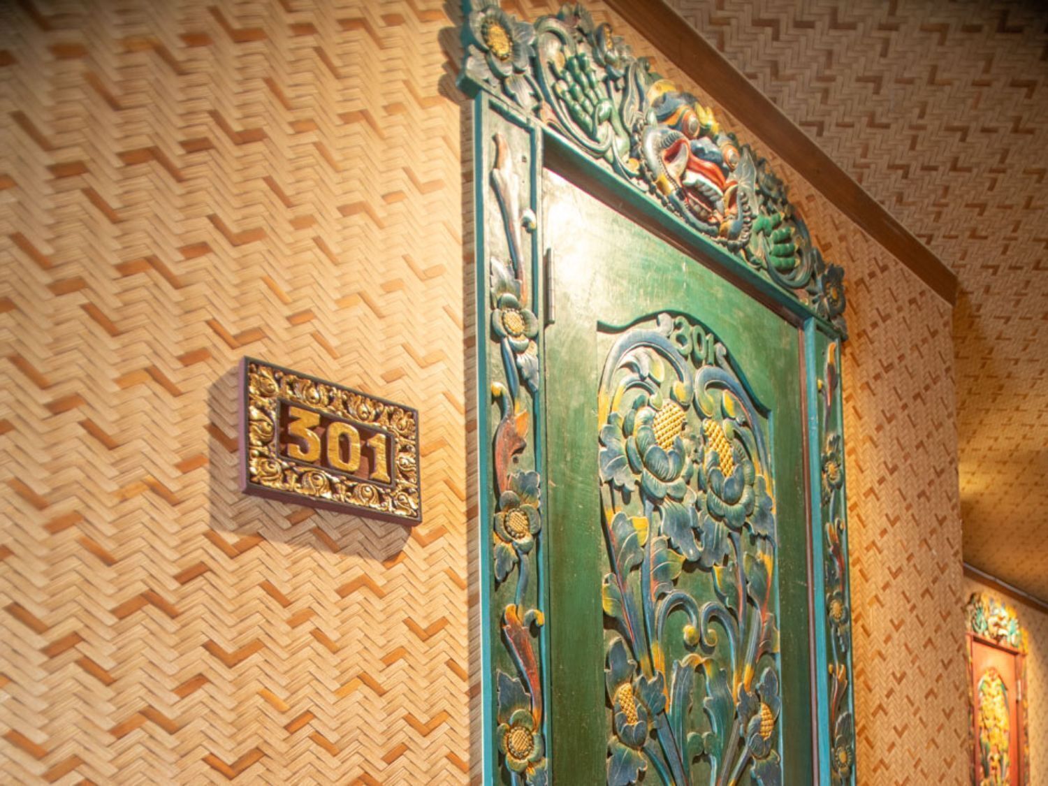 A room with a decorative door, a number plaque, and a patterned wall.