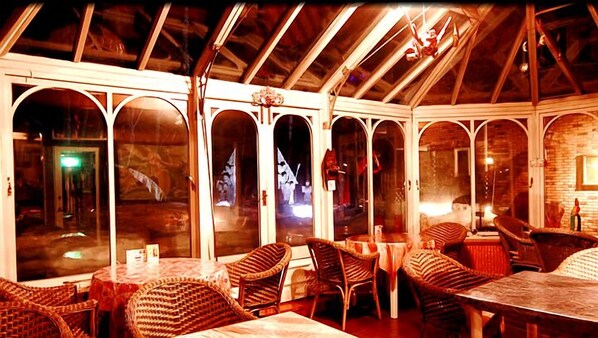 A covered outdoor seating area with wicker furniture and a high ceiling. - Estivant Club (Tsumagoi)