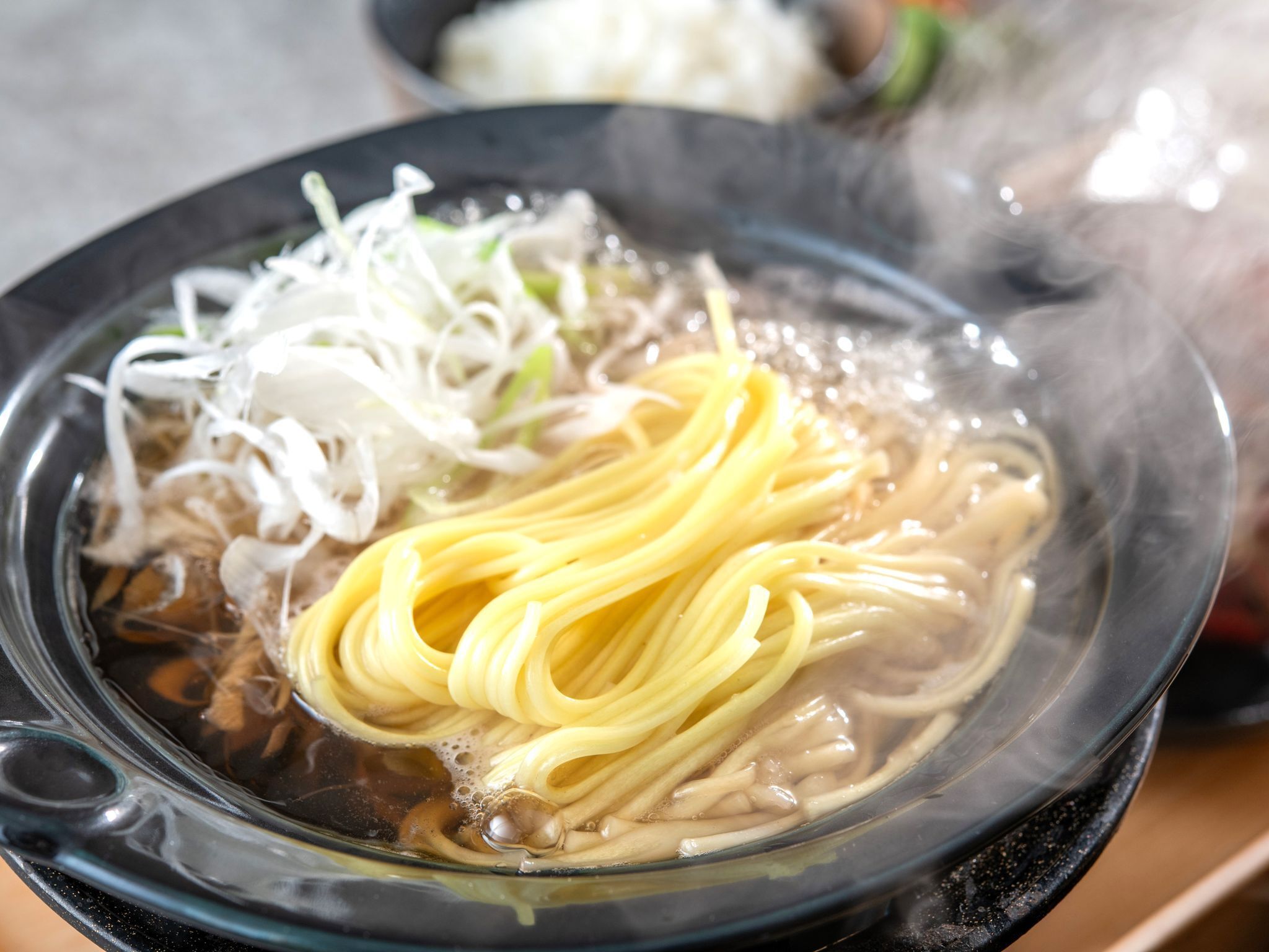 A bowl of ramen with noodles, vegetables, and broth.