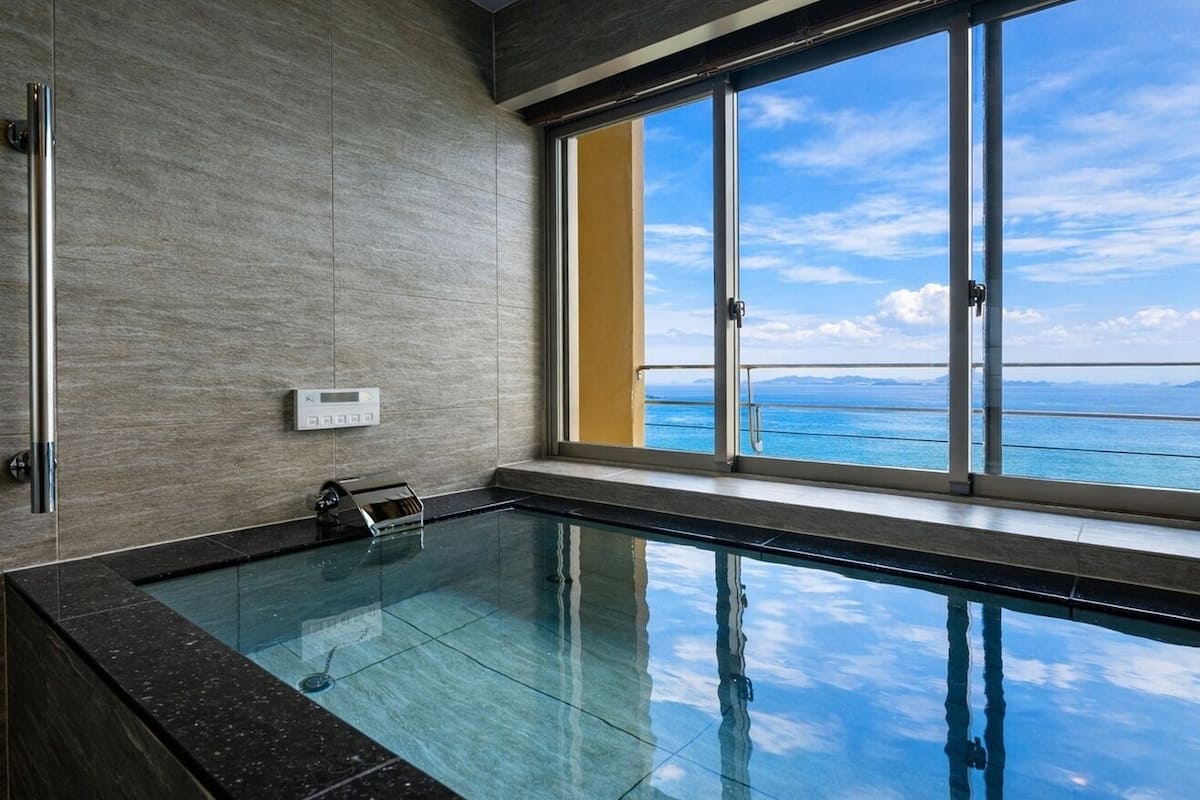 Una piscina interna moderna con un'ampia finestra vista mare.
