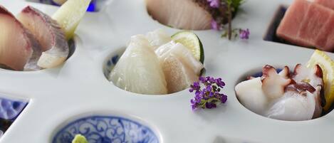 A variety of seafood dishes arranged on a white plate with a blue pattern.