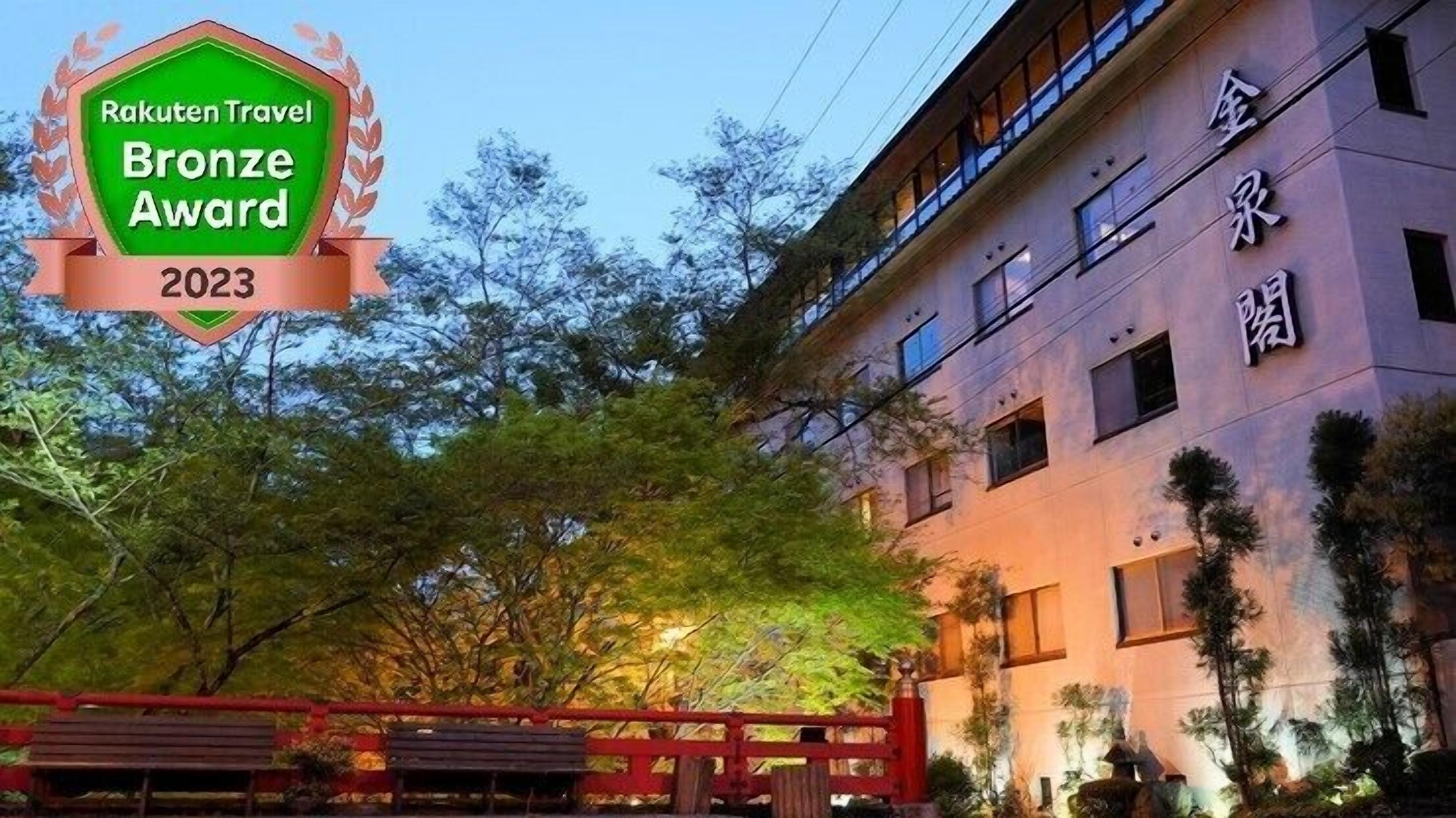 A building with a traditional architectural style, featuring a prominent entrance with a red gate and a well-lit facade.
