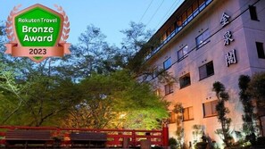 A building with a traditional architectural style, featuring a prominent entrance with a red gate and a well-lit facade. - Sanage Onsen Hotel Kinsenkaku (Toyota)