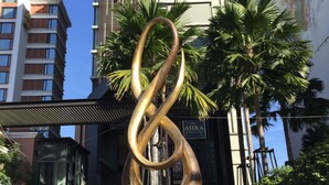 A modern sculpture in front of a building with a sign that reads "The ASTRA."