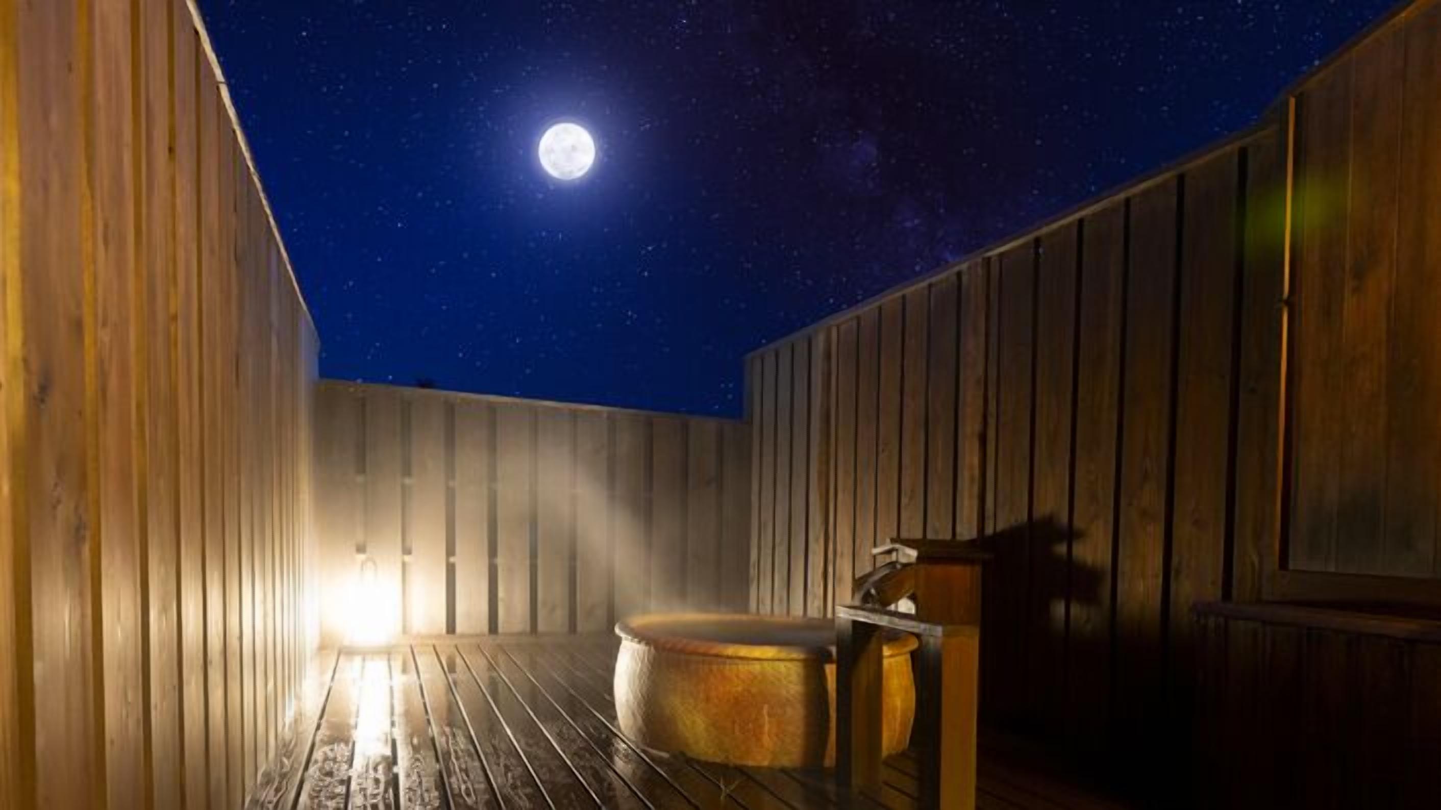 A wooden room with a large round hot tub, a wooden bench, and a wooden wall.