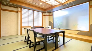 A traditional Japanese room with tatami flooring, a low table, and shoji screens.