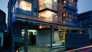 Un edificio moderno de varios pisos con grandes ventanales y un área de entrada cubierta.