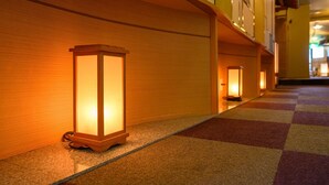 Un pasillo con alfombra a cuadros y apliques de luz.