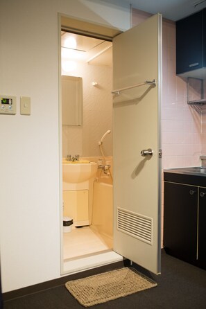 A bathroom with a toilet, sink, and shower.