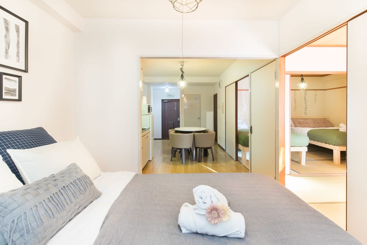 Una habitación de hotel con cama, una pequeña mesa de comedor y una zona de descanso separada.