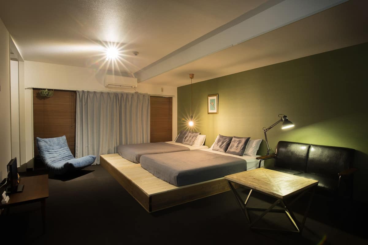 Un dormitorio moderno con cama, escritorio, silla y sofá.