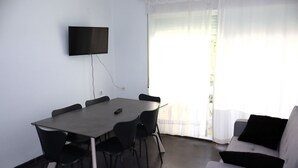 A conference room with a table, chairs, a flat-screen TV, and a sofa. - Los Monegros (Peñiscola)