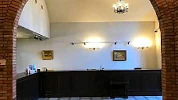 An interior space with a brick archway leading to a kitchen area with a counter and cabinets.