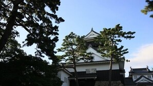 A traditional Japanese building with a prominent central tower, surrounded by trees. - Okazaki Ohwa Hotel (Okazaki)