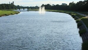Ein Fluss mit einer Brücke und einem Brunnen.