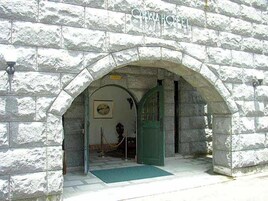 Una entrada de piedra arqueada a un edificio con la leyenda 'CHINA HOTEL', una puerta verde y un felpudo.