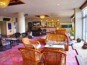 A hotel lobby with wicker furniture, a bar area, and a large window. - Nakamuraya (Toba)