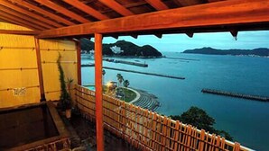 A covered outdoor area with a view of a body of water and distant landforms. - Nakamuraya (Toba)