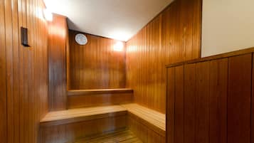 A wooden sauna with a bench and a wall-mounted clock.