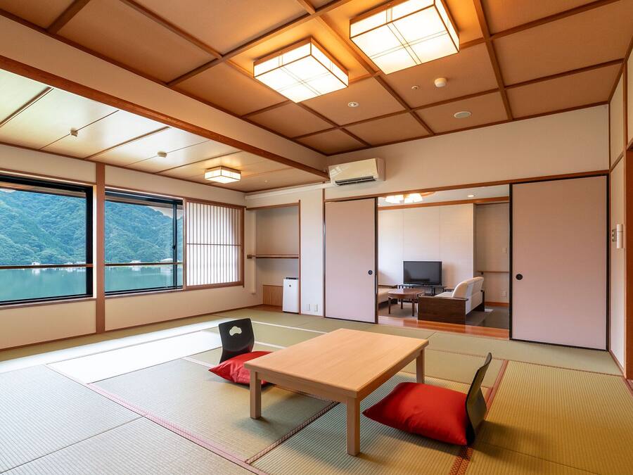 Een traditionele Japanse kamer met tatami vloerbedekking, een houten tafel en een televisie.